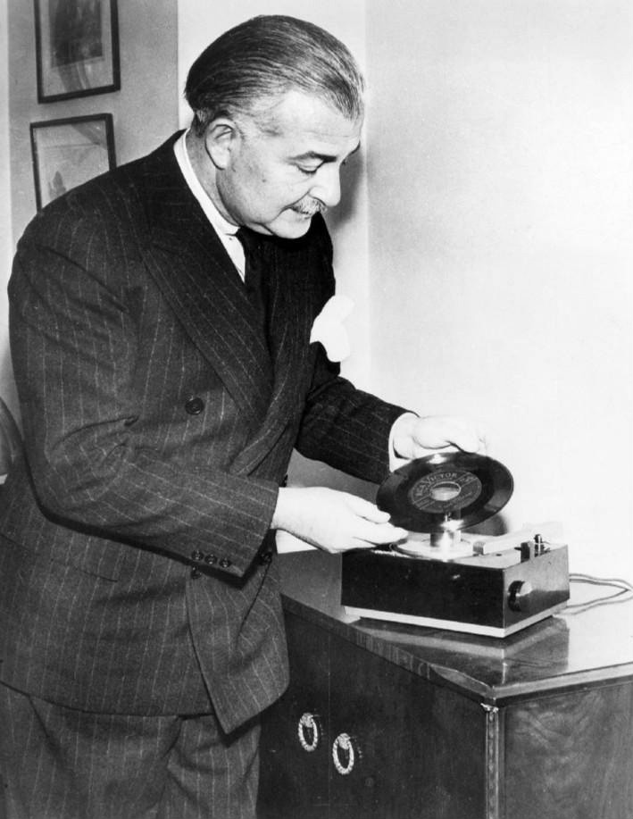 A man placing a 45 rpm record onto a phonograph, 1949 photograph
