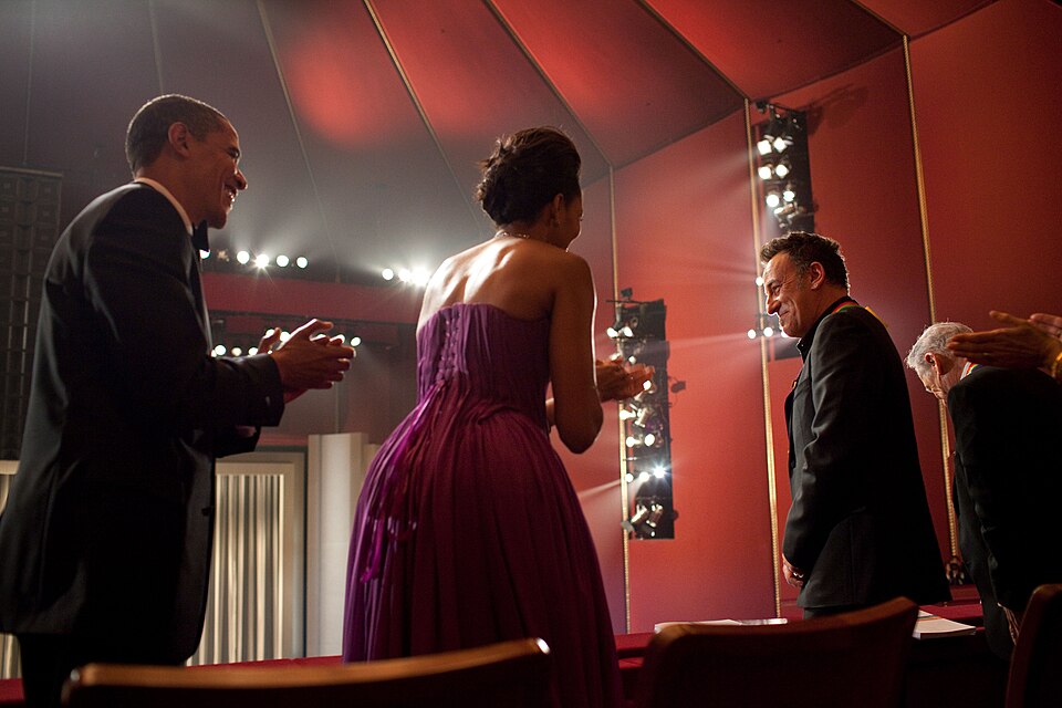 President Barack Obama and Michelle Obama applauding as Bruce Springsteen stands in the honorees box at the Kennedy Center